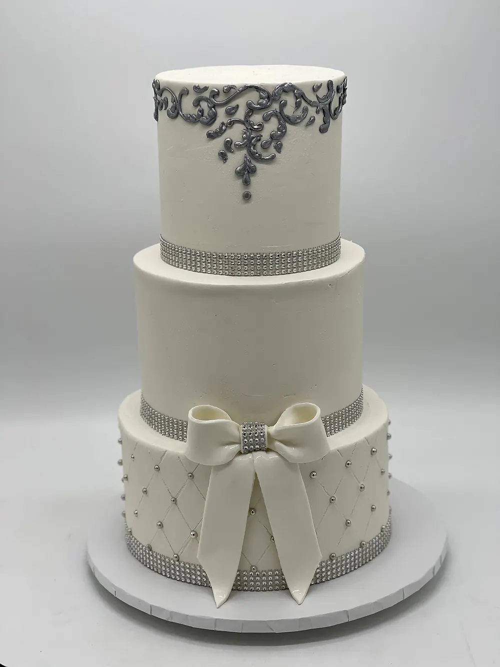 Photo of a 3 tier white wedding cake with white and silver design elements made by CakEffect in Hoover, AL