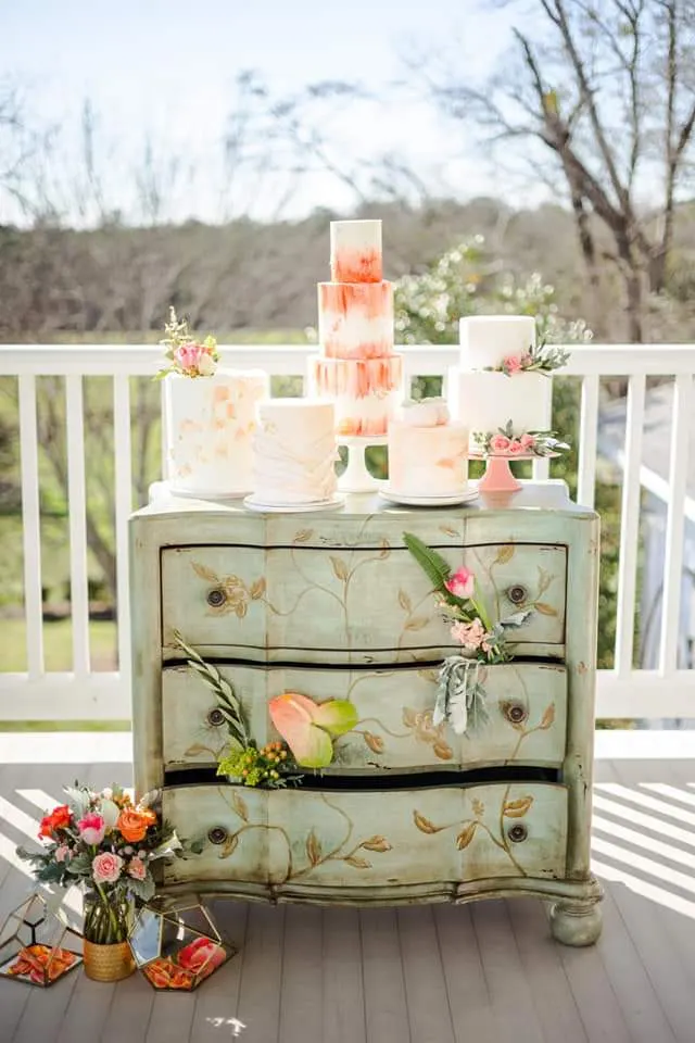 Photo of a vintage dresser with several beautiful wedding cakes designed by Sweetthang's Custom Cakes & More in Northport, AL